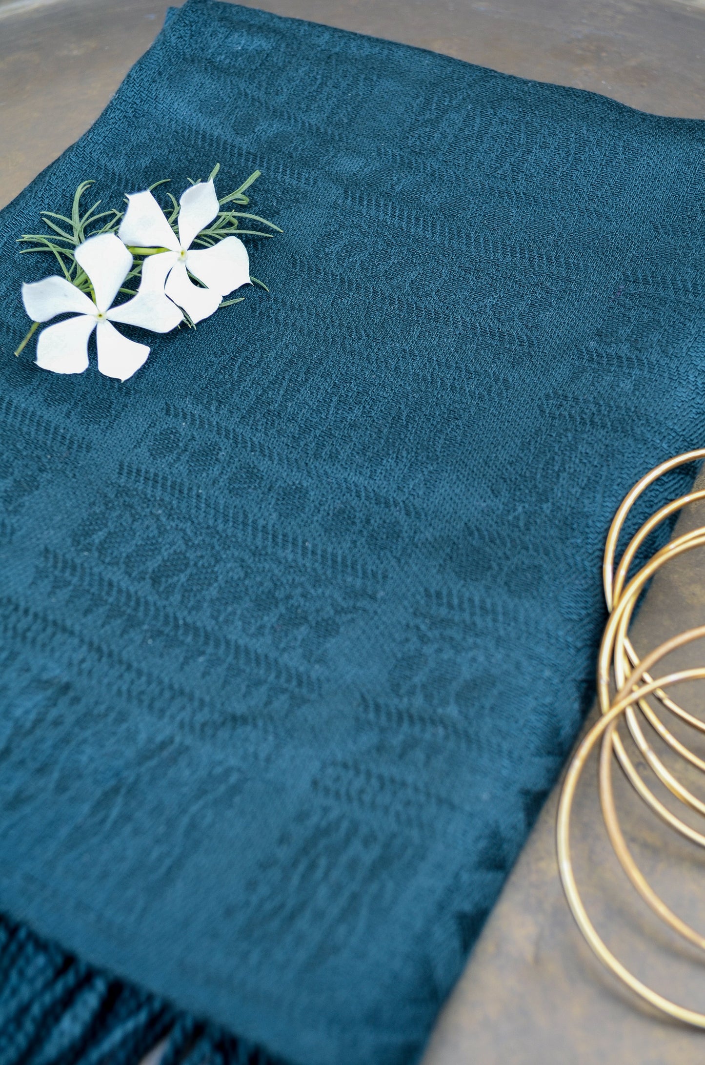 Elegant black green jacquard stole with a textured pattern, styled with flowers and accessories