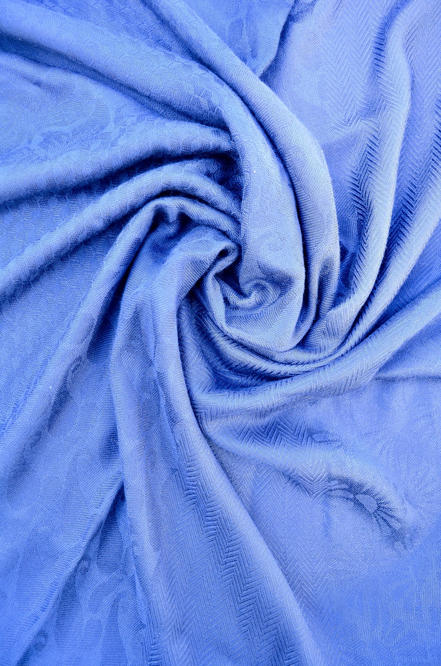 Soft blue jacquard stole draped elegantly showcasing intricate fabric texture