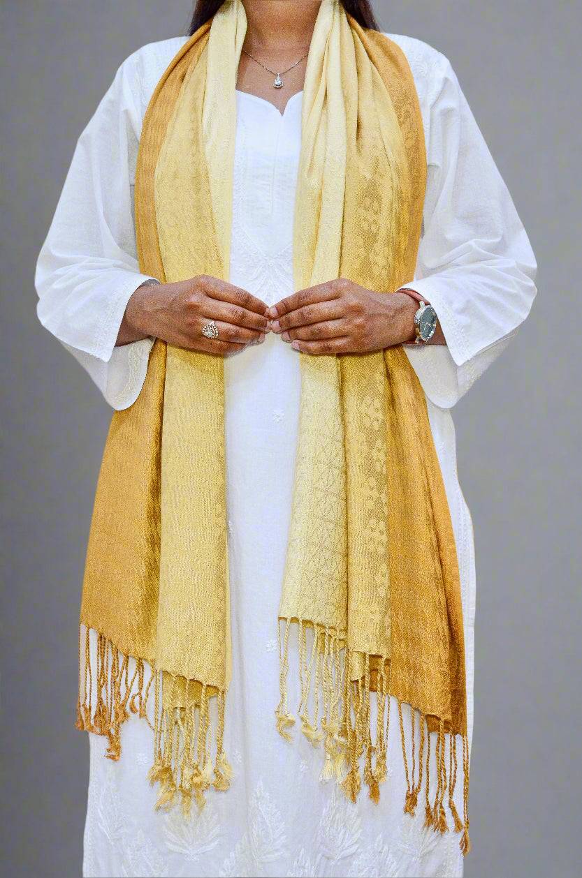 Elegant golden jacquard stole draped elegantly over a white outfit, featuring intricate designs