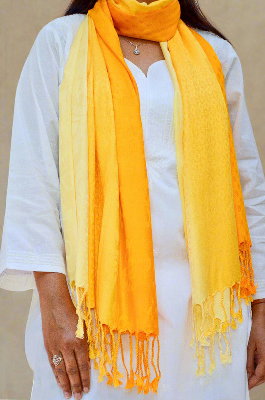Elegant golden yellow jacquard stole styled with a white outfit, featuring intricate patterns and fringed edges