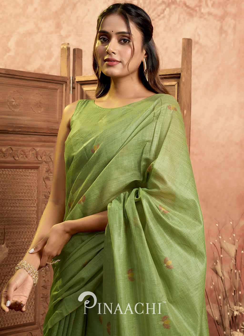 Pinaachi green jamdani saree with subtle floral motifs worn by woman in elegant setting