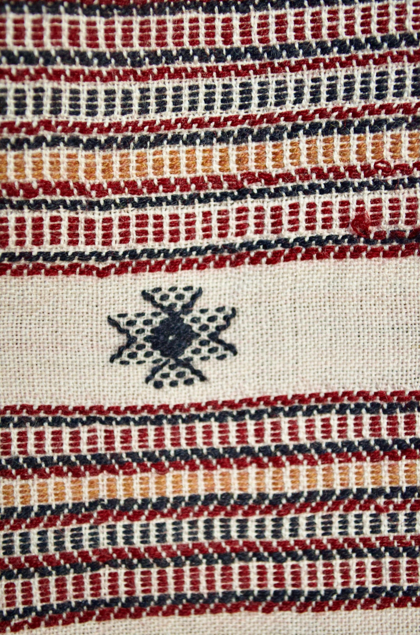 Hand woven merino wool stole featuring intricate geometric patterns and warm colors