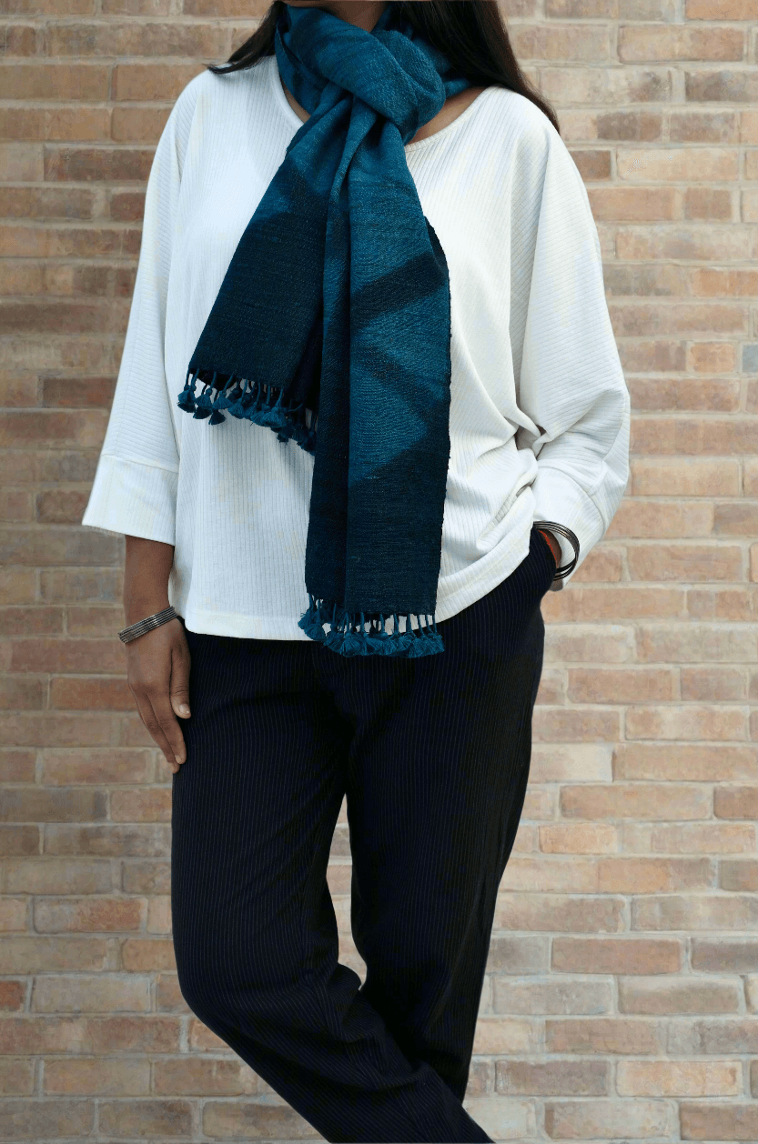 Stylish handwoven merino wool stole in deep blue worn by a model with a casual outfit
