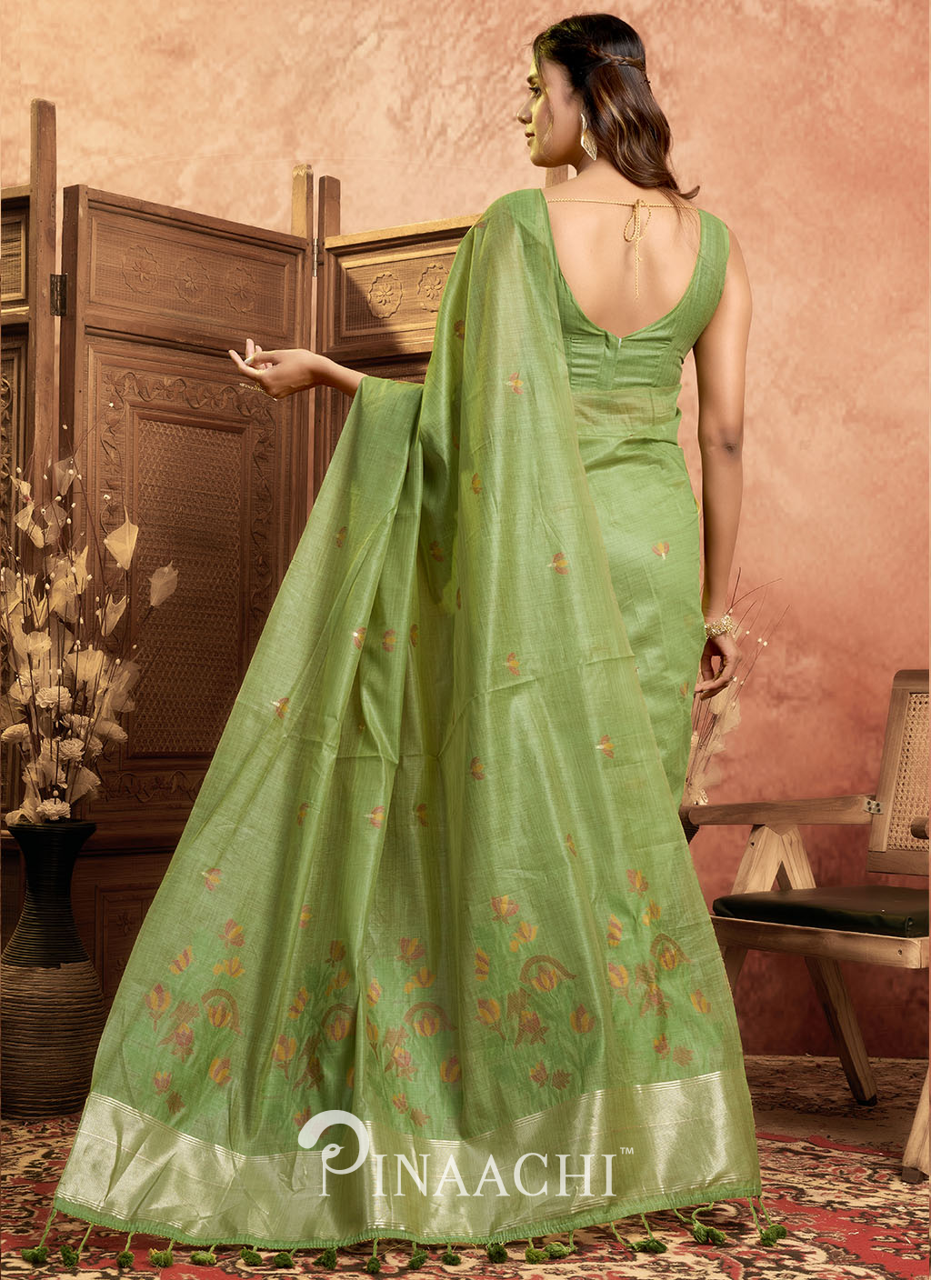 Pinaachi green jamdani saree with floral motifs and golden border draped on model
