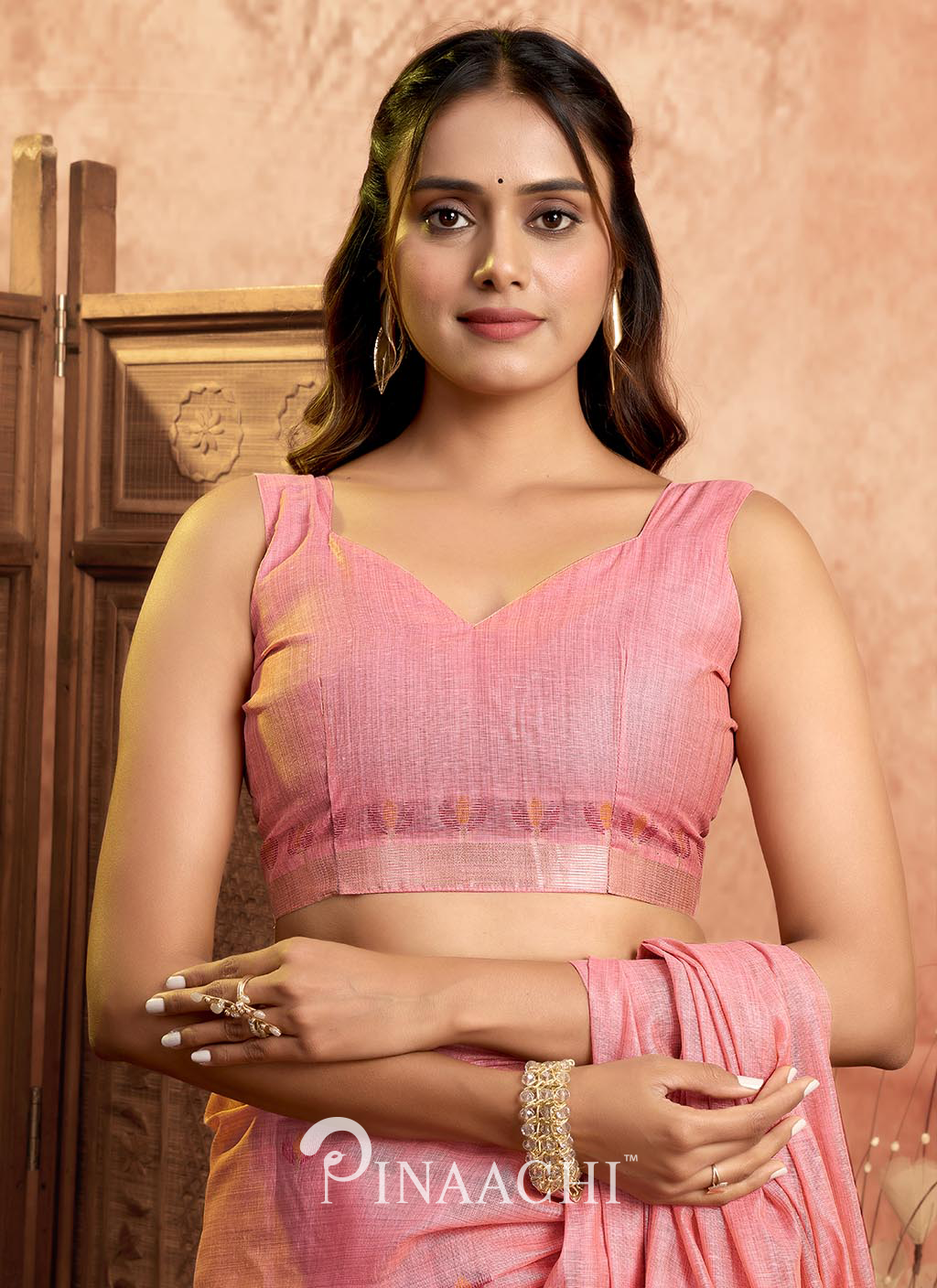 Pinaachi pink jamdani saree worn by model with sleeveless blouse and traditional jewelry