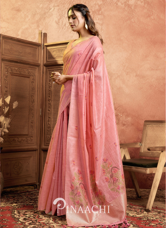 Pinaachi pink jamdani saree with floral patterns worn by a woman in traditional setting