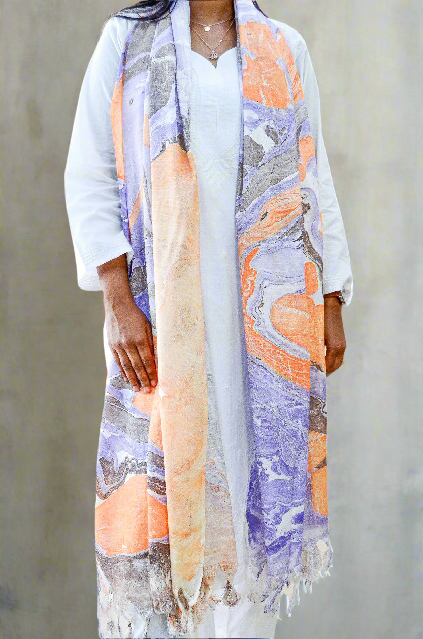 Woman wearing a marble printed cotton silk dupatta in vibrant orange and purple tones for a stylish look