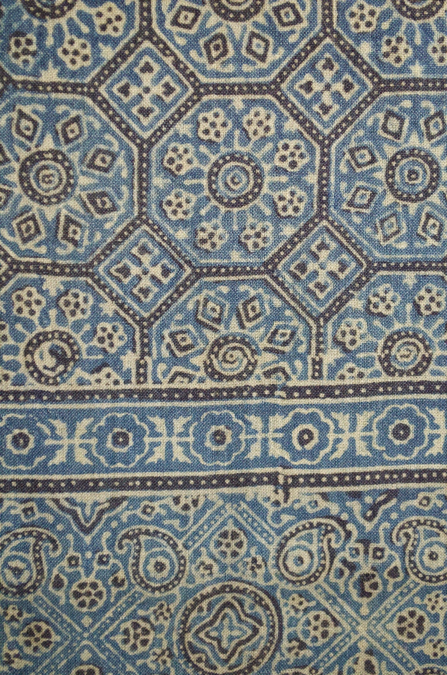 Intricate patterns on a Merino wool Ajrakh stole featuring blue and cream hues