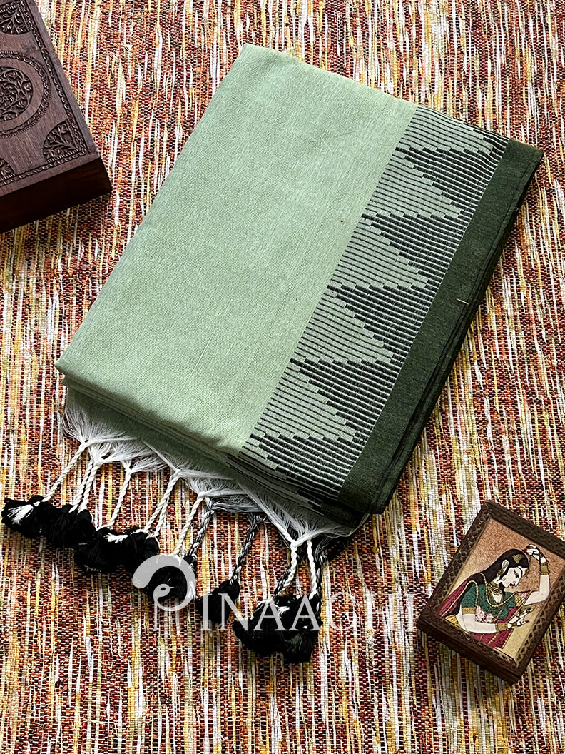 Elegant sage green cotton saree featuring intricate black border and tassels for traditional wear