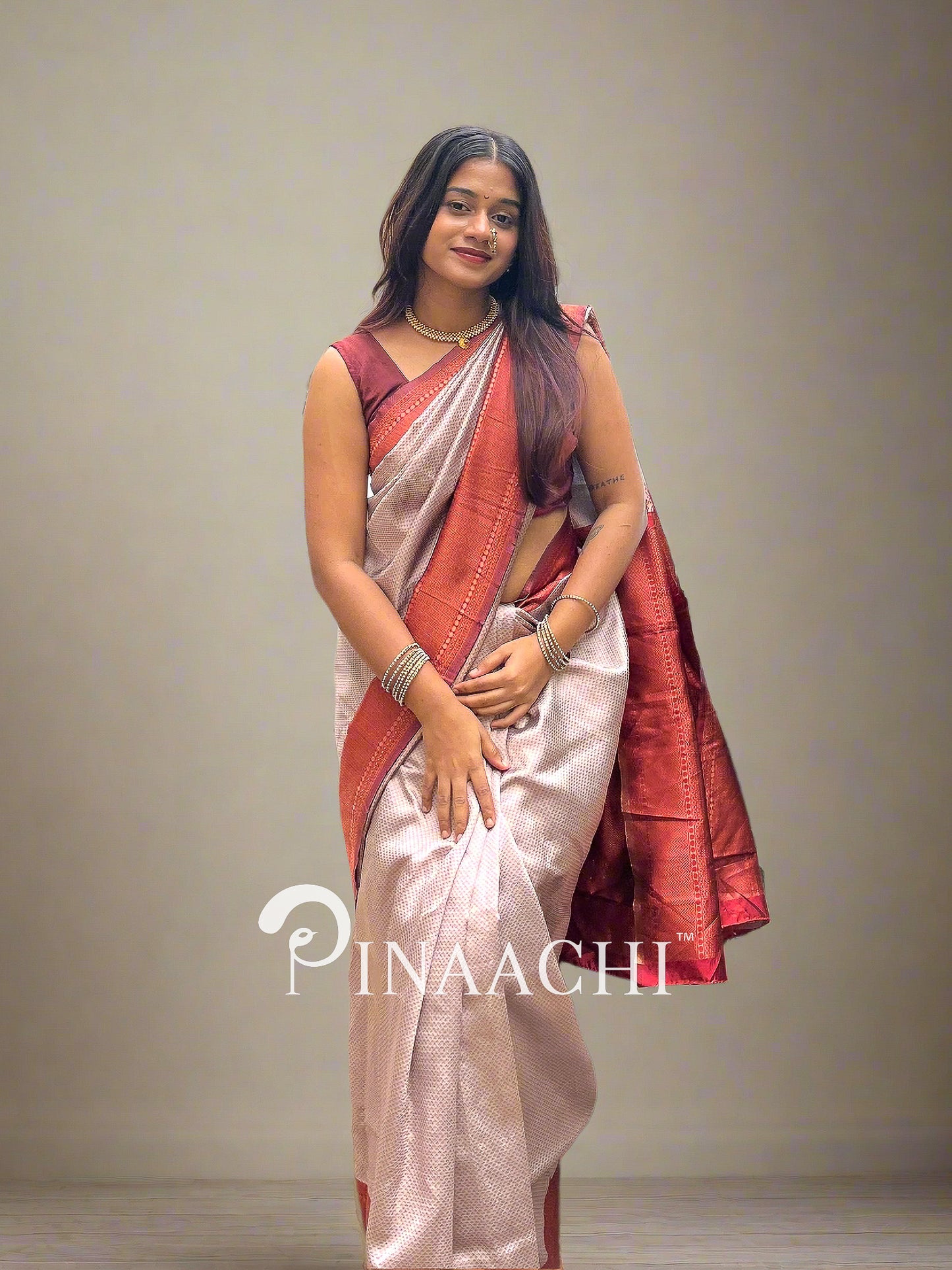 Elegant beige and maroon licchi silk saree draped on a model showcasing traditional style and design
