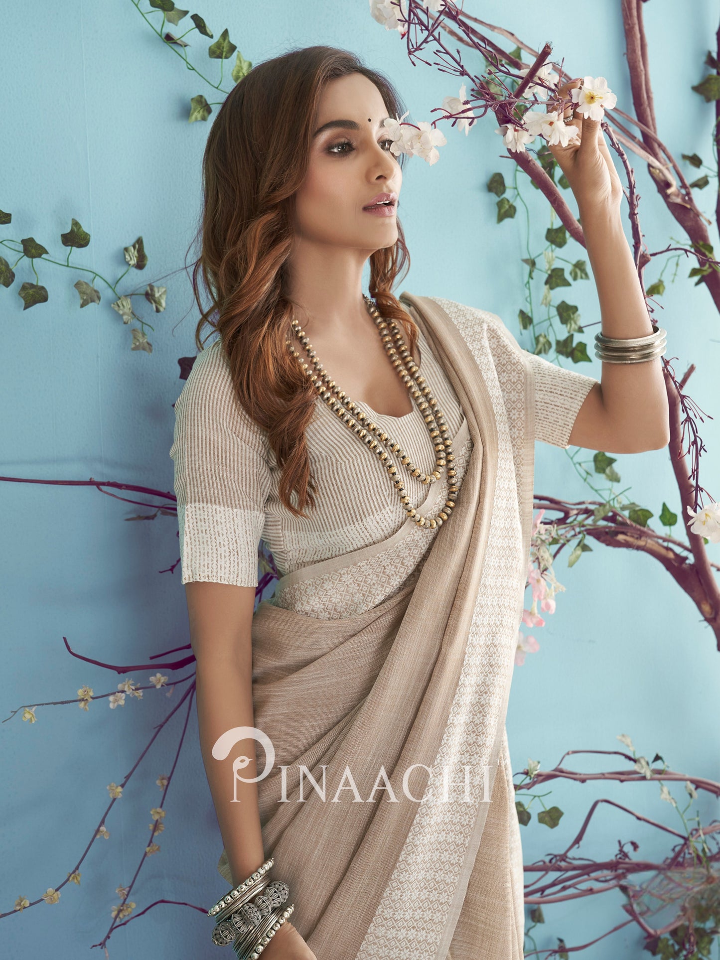 Elegant beige soft linen saree by Pinaachi styled with a matching blouse and accessories