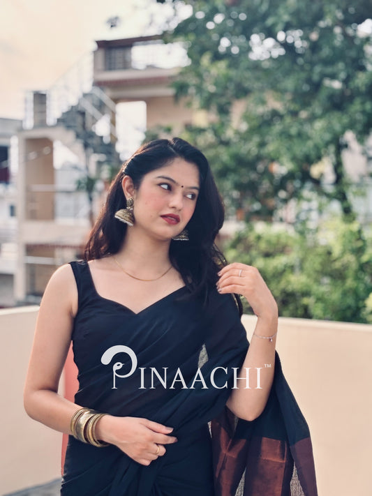 Elegant black cotton saree with zari border showcased by a model for a stunning festive look