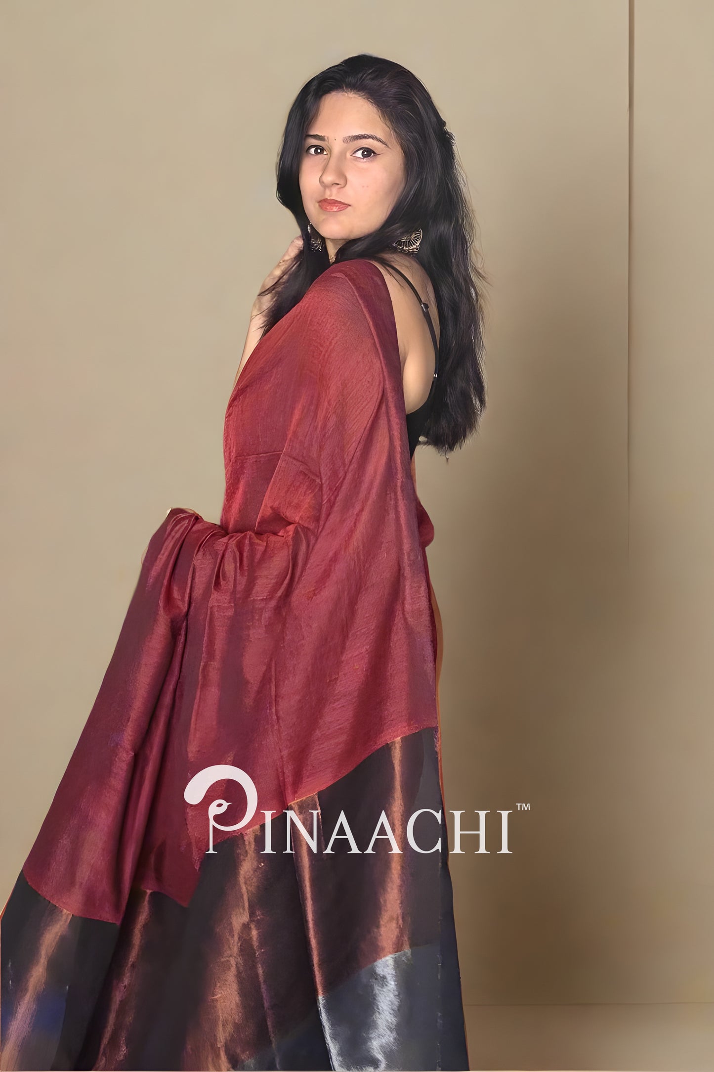 Elegant brick red cotton saree with zari draped stylishly on a model, showcasing its rich texture