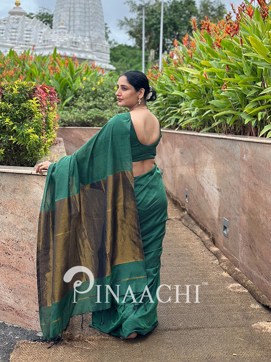 Elegant emerald green cotton saree with contrasting gold border, perfect for festive occasions