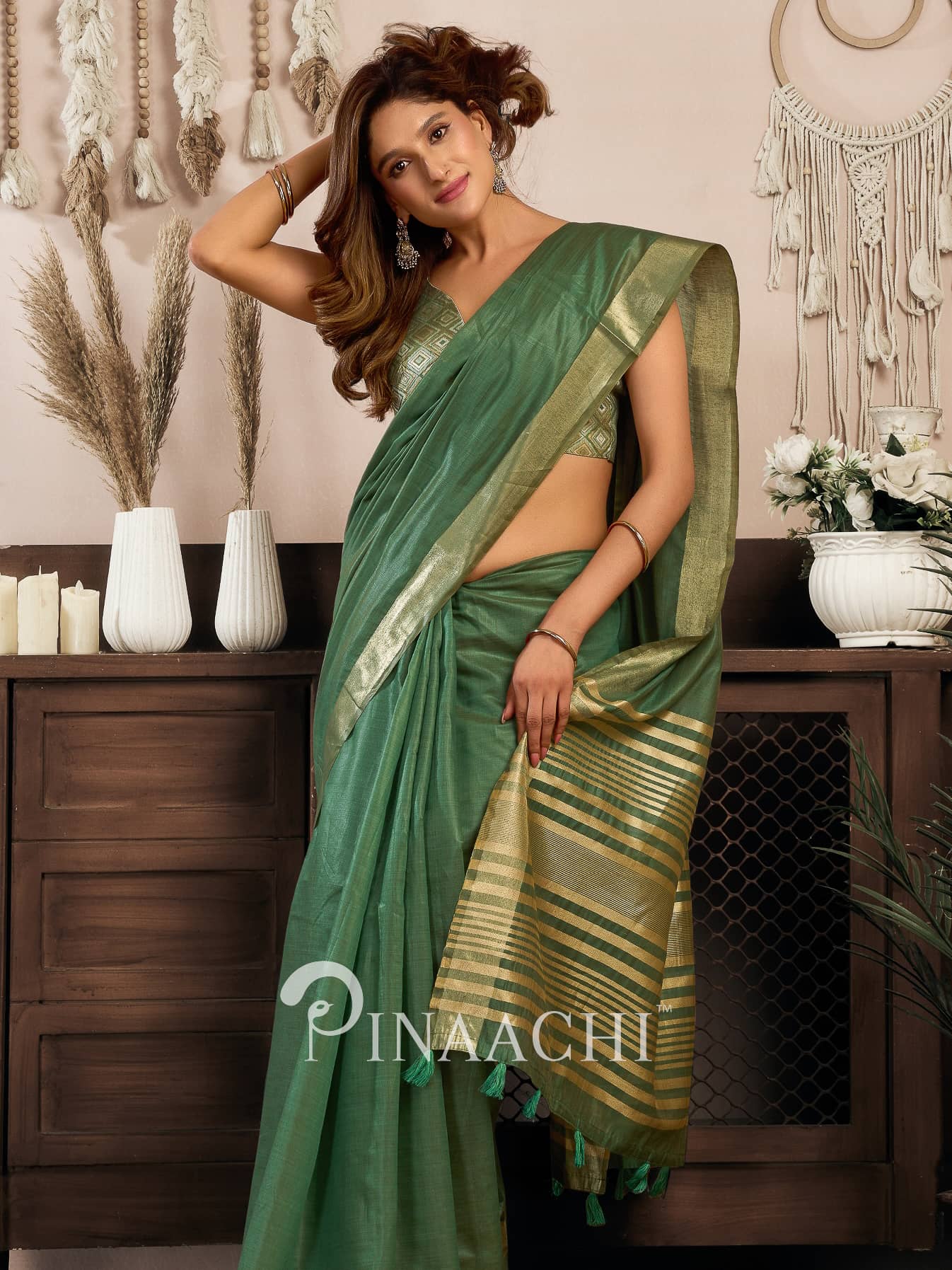 Stylish woman wearing a green cotton silk saree with traditional design, perfect for festive occasions