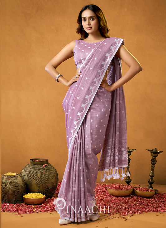 Woman wearing a lavender pinaachi jamdani saree with white geometric patterns and tassels