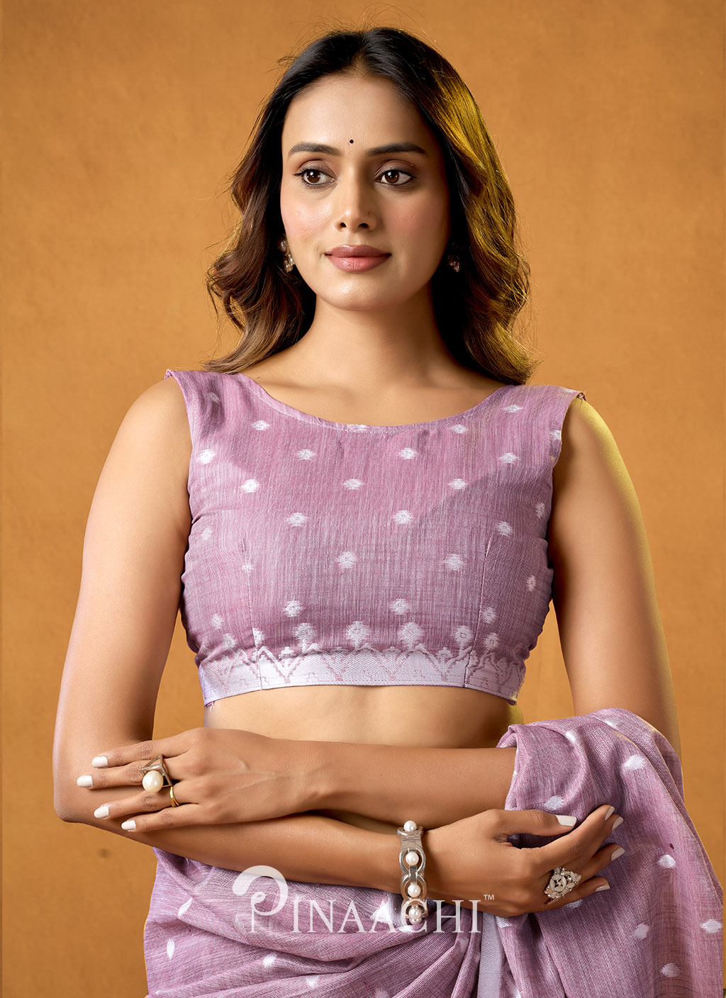 Woman wearing a light purple pinaachi jamdani saree with white polka dots and a sleeveless blouse