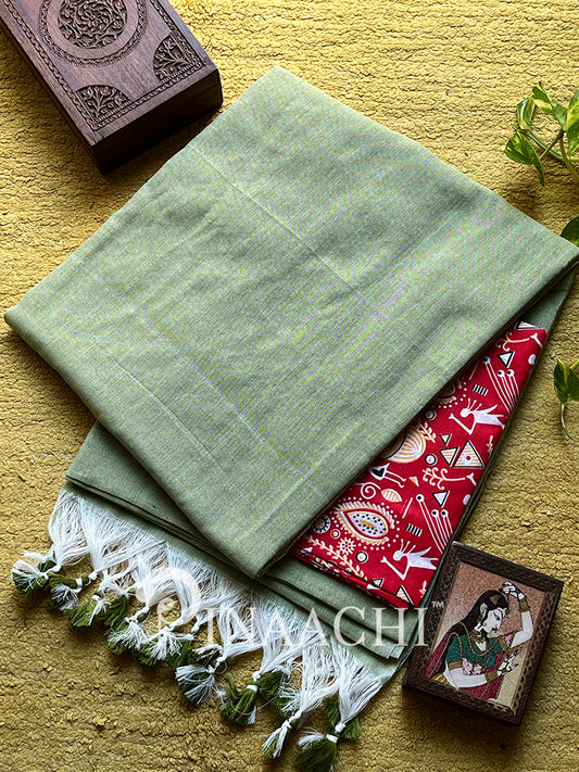 Mint green cotton saree draped elegantly alongside intricate red fabric and decorative accessories