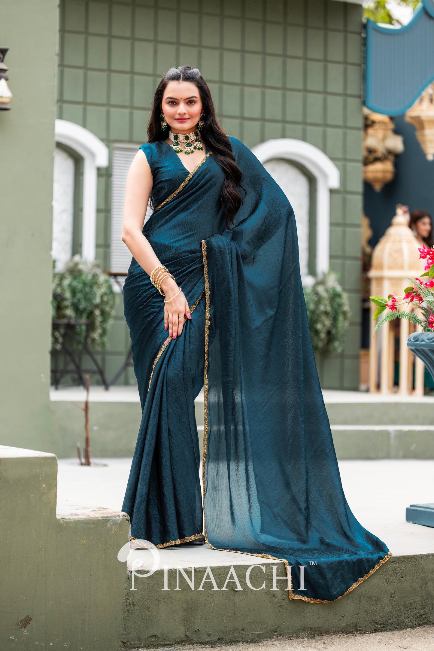Elegant woman wearing a Pinaachi Morpich chiffon saree in deep blue with gold border and matching blouse