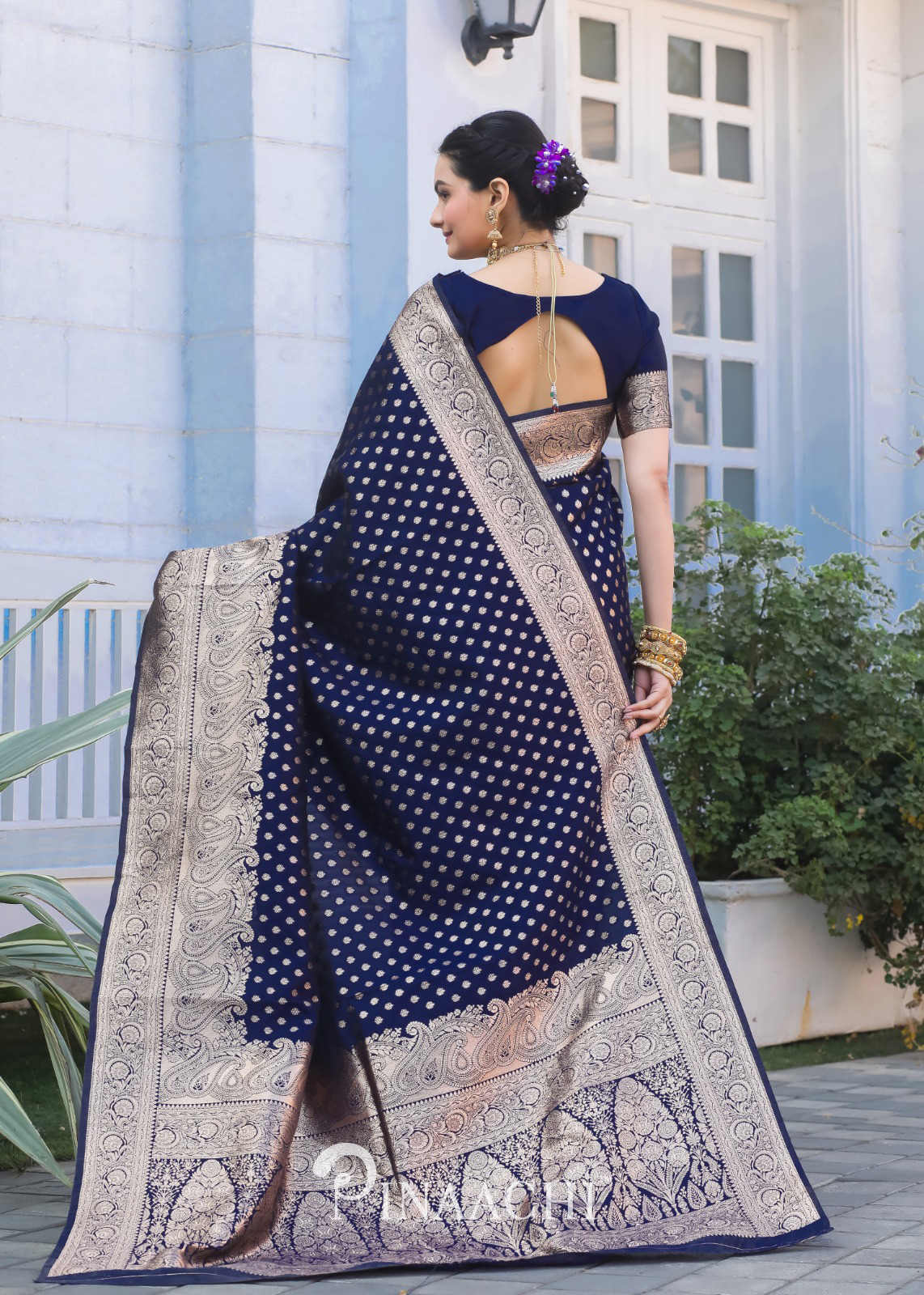 Woman wearing Pinaachi Navy Blue Banarasi Silk Saree with intricate gold zari work and traditional design