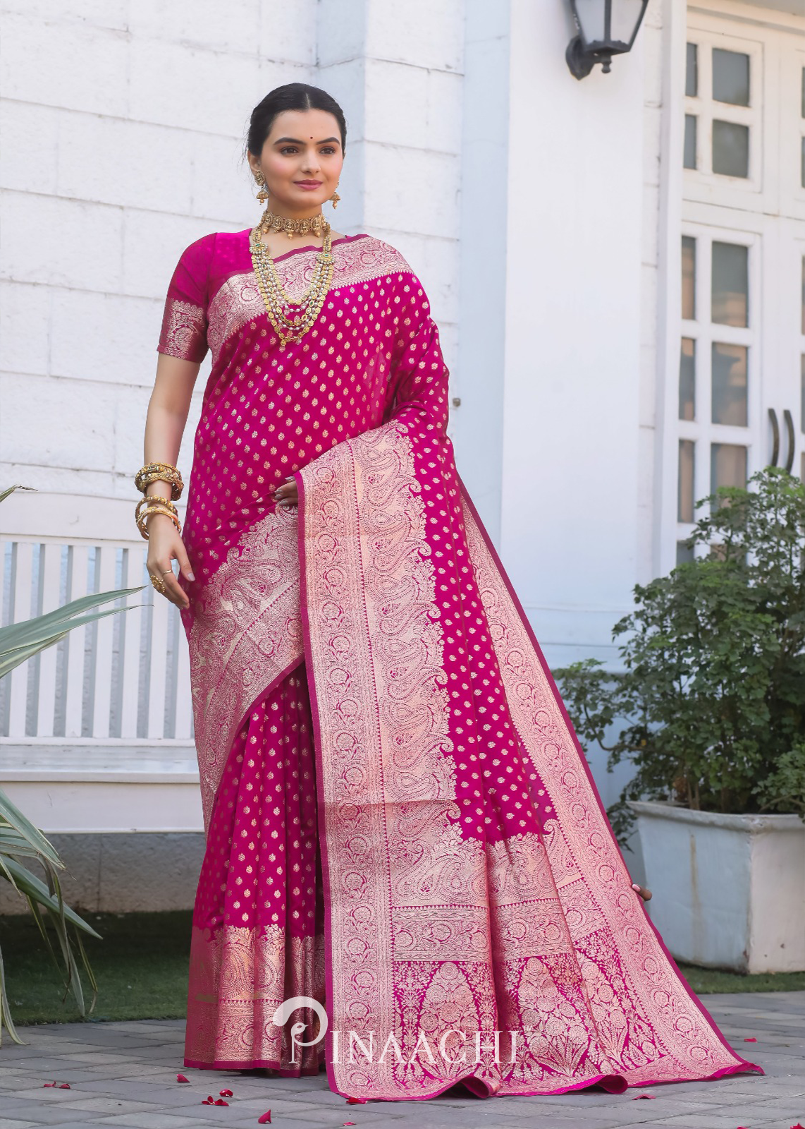 Woman wearing Pinaachi Pink Banarasi Silk Saree with intricate golden patterns and traditional jewelry