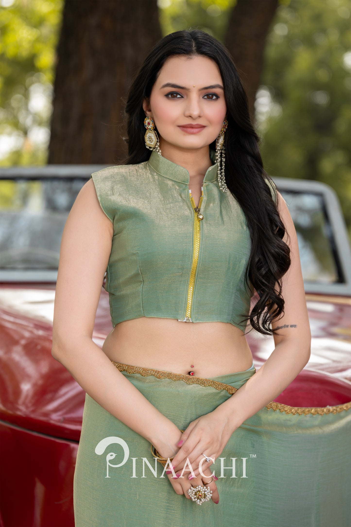 Pinaachi pista green chiffon saree worn by a woman with long hair and gold jewelry in outdoor setting