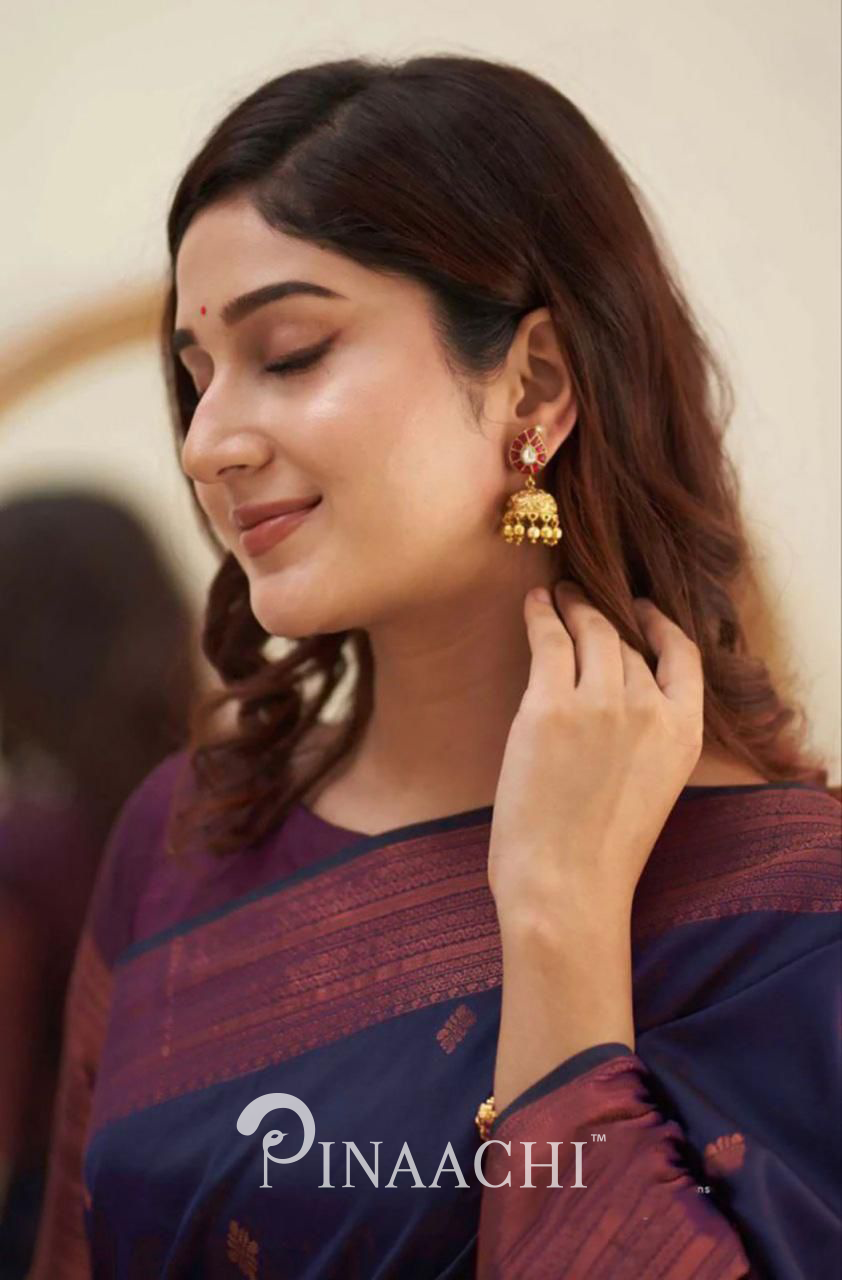 Woman wearing Pinaachi Purple Litchi Silk Saree with traditional gold jhumka earrings and subtle makeup