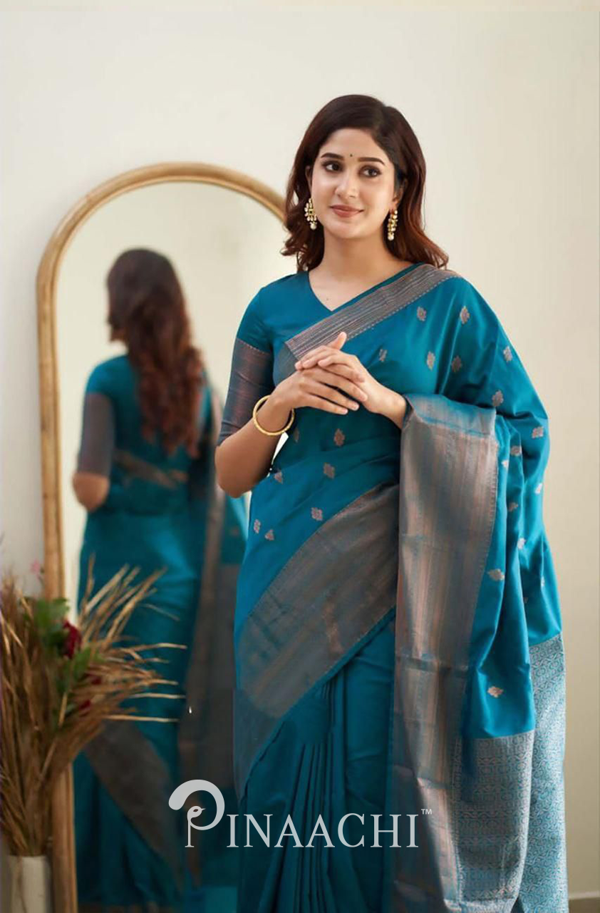Elegant woman wearing Pinaachi Turquoise Litchi Silk Saree with subtle golden motifs and complementing blouse