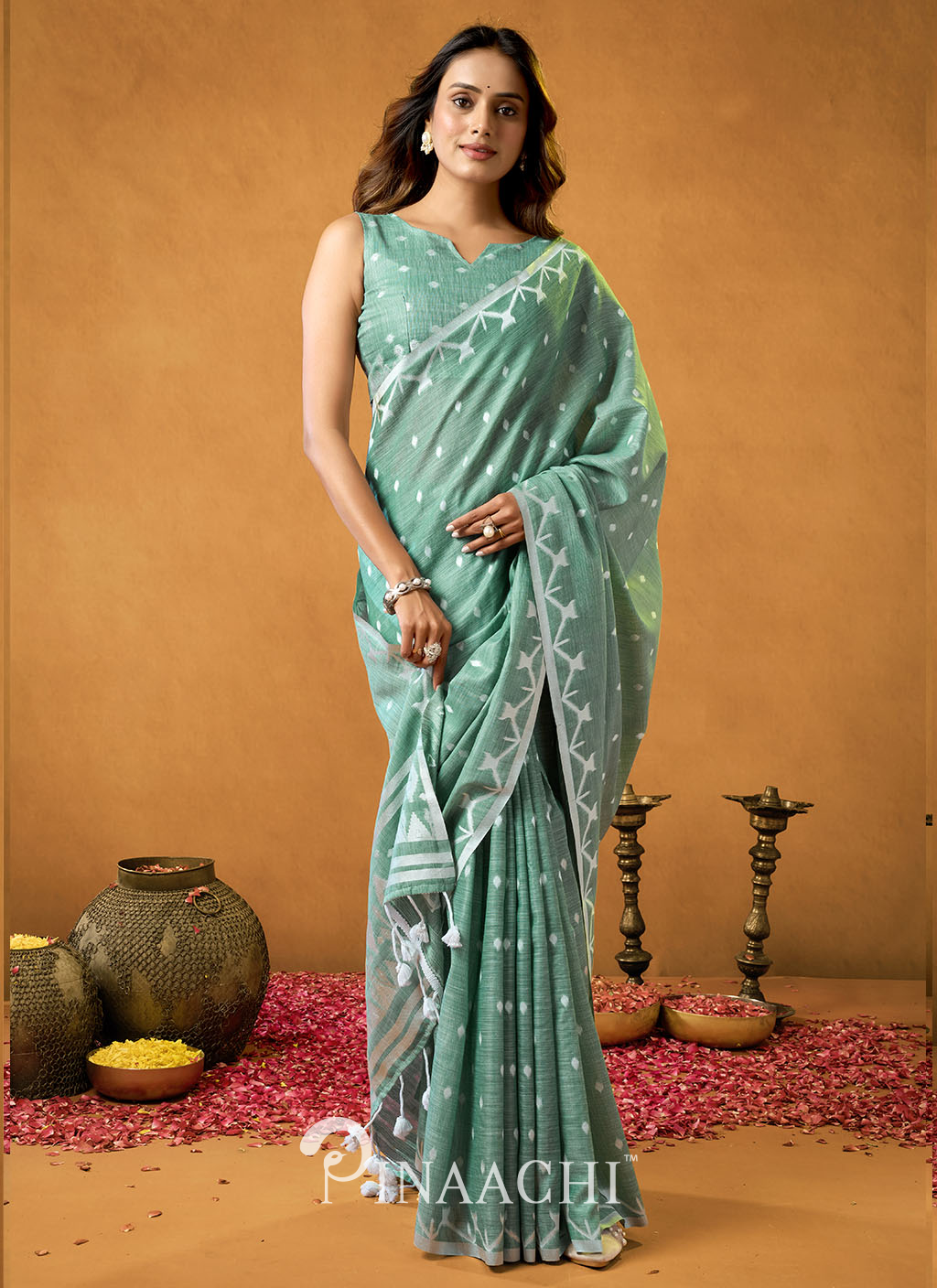 Woman wearing a Rama Cotton Jamdani Saree by Pinaachi in a light green color with white patterns