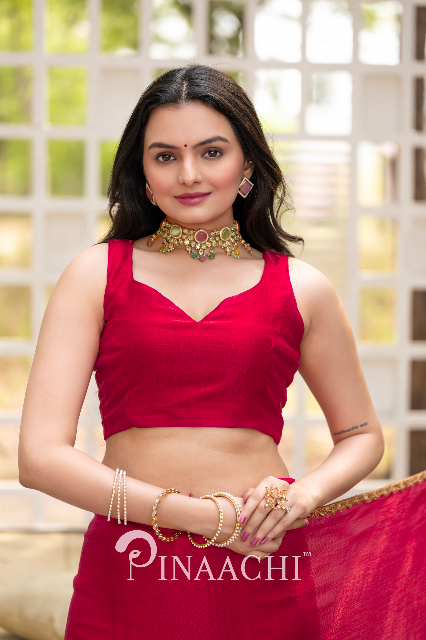 Woman wearing Pinaachi solid cherry red chiffon saree with matching blouse and traditional jewelry