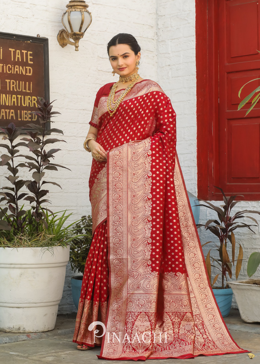 Woman wearing Pinaachi Red Banarasi Silk Saree with intricate gold zari work and traditional jewelry