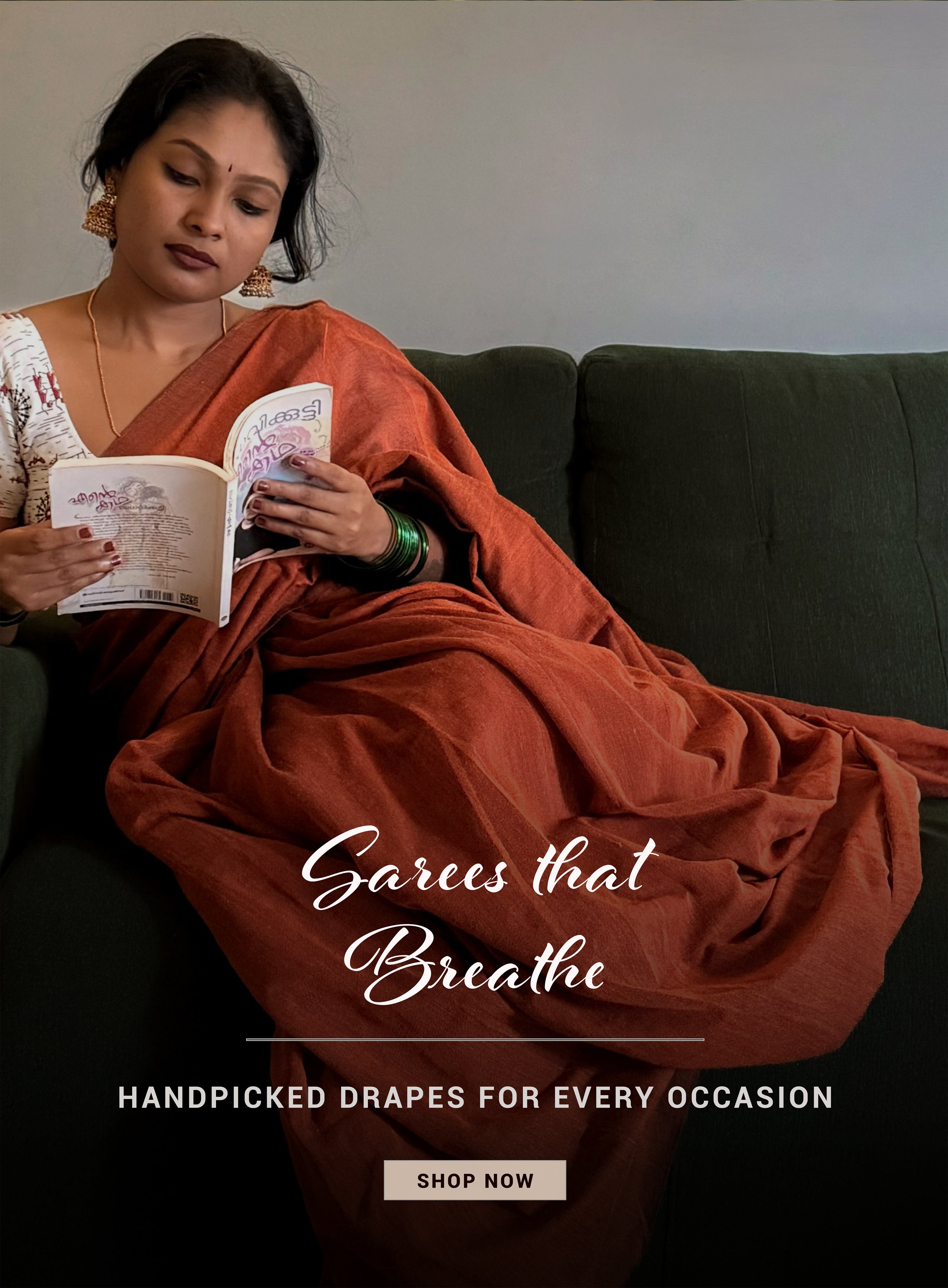 Woman in a rust-colored saree reading a book on a dark green sofa with text overlay.