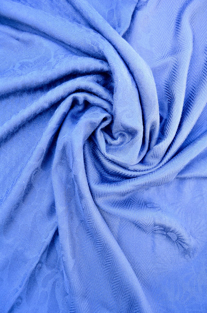 Soft blue jacquard stole draped elegantly showcasing intricate fabric texture