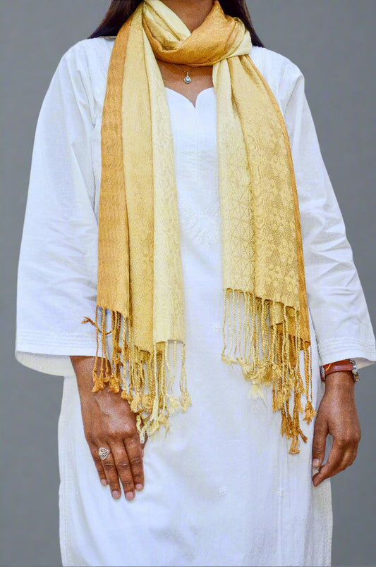 Elegant golden jacquard stole styled over a white kurta with fringed ends