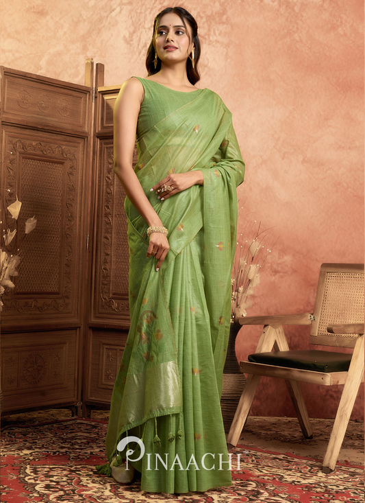 Pinaachi green jamdani saree with intricate designs worn by woman in elegant indoor setting