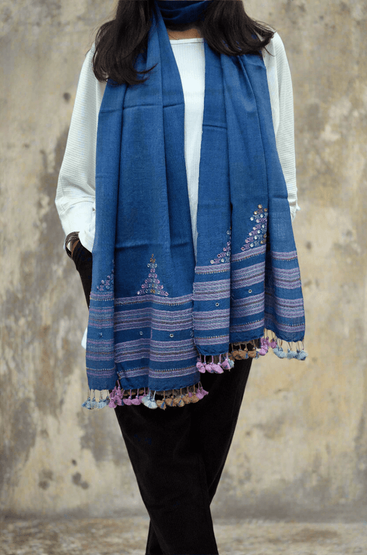 Elegant handwoven merino wool stole in deep blue with vibrant embroidery and fringe detailing