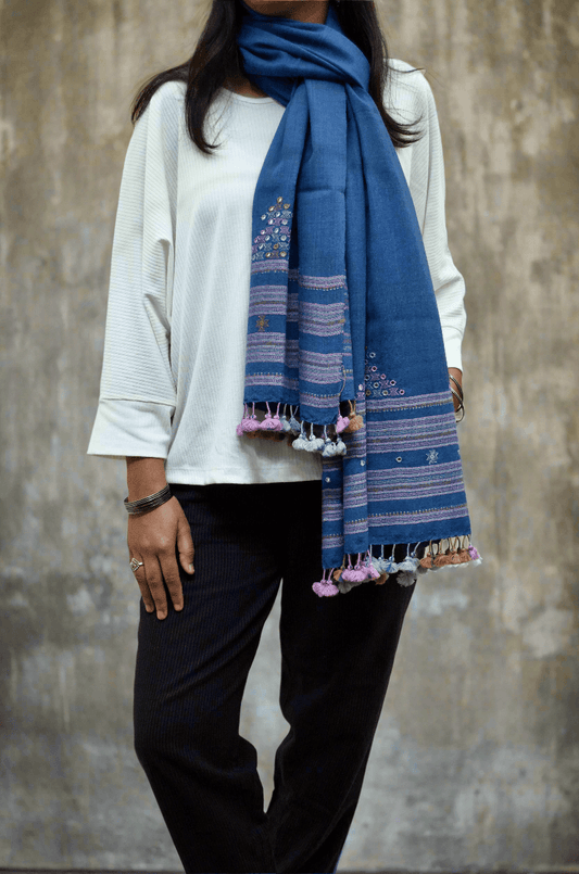 Elegant handwoven merino wool stole in blue with intricate patterns and tassels, perfect for stylish layering.