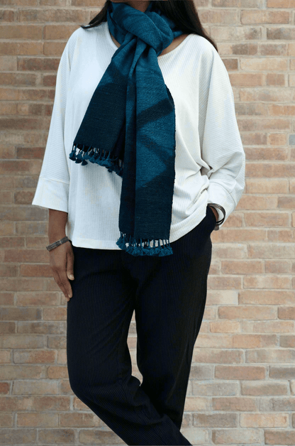 Stylish handwoven merino wool stole in deep blue worn by a model with a casual outfit