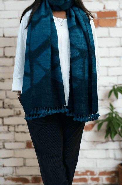 Elegant handwoven merino wool stole in deep blue, featuring intricate patterns and fringed edges