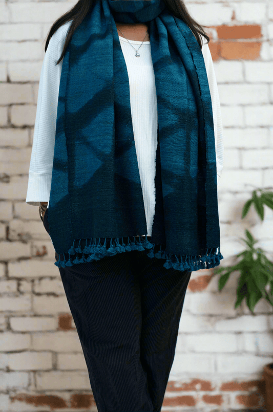 Elegant handwoven merino wool stole in deep blue, featuring intricate patterns and fringed edges