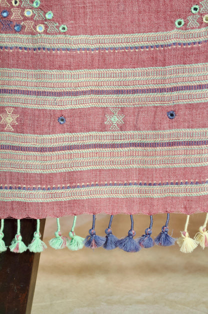 Handwoven merino wool stole with intricate embroidery and colorful tassels at the hem