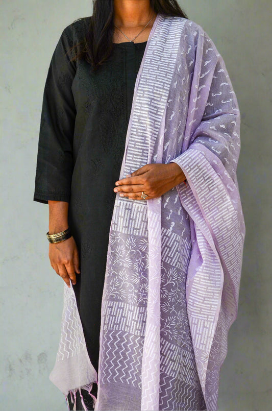 Woman wearing a stylish lilac chanderi silk dupatta draped over a black kurta, showcasing elegant patterns
