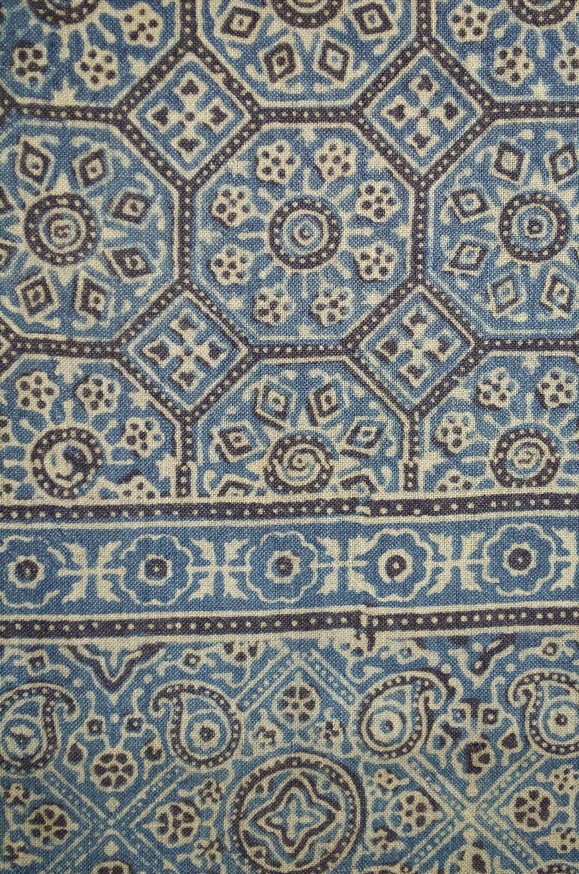 Intricate patterns on a Merino wool Ajrakh stole featuring blue and cream hues