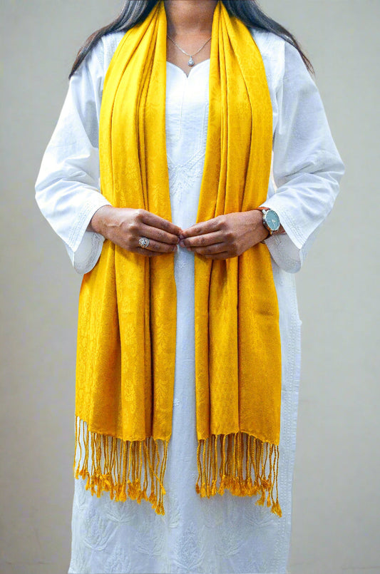 Woman wearing a mustard yellow jacquard stole with fringed edges for a stylish look