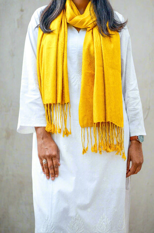 Mustard yellow jacquard stole draped elegantly over a white kurta for a stylish look