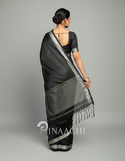 Elegant black mul tissue handloom saree with intricate silver detailing and tassel border