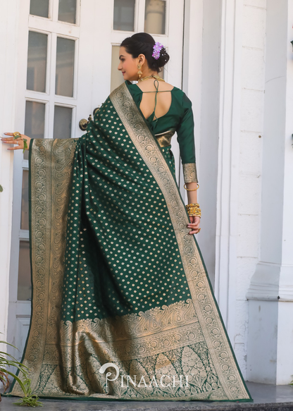 Woman wearing Pinaachi bottle green Banarasi saree with intricate gold zari work and traditional design