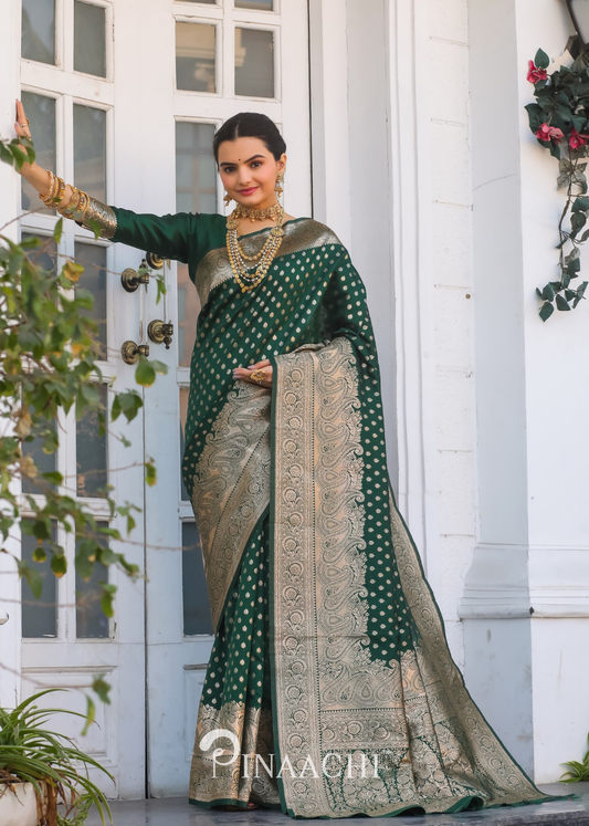 Woman wearing a Pinaachi bottle green Banarasi saree with gold zari work and traditional jewelry