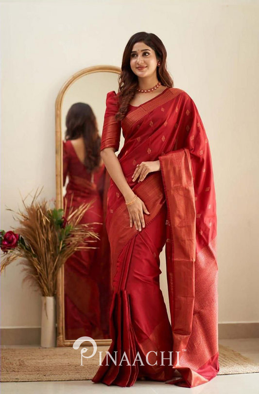 Pinaachi Cherry Red Litchi Silk Saree worn by woman standing near a mirror with floral decor