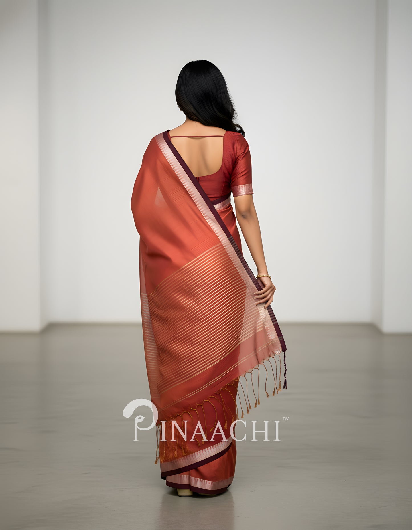 Elegant coral blush mul tissue saree with intricate draping and a stylish border from Pinaachi